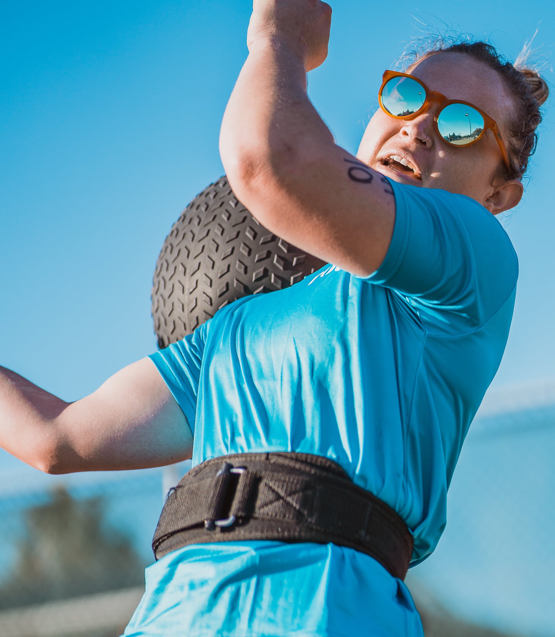 Female Cross Fit Athlete throwing ball over shoulder