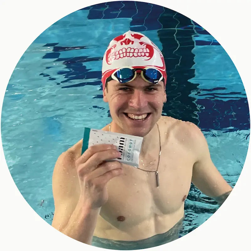 Professional Triathlete in a swimming pool holding Energy Nut Butter Packet